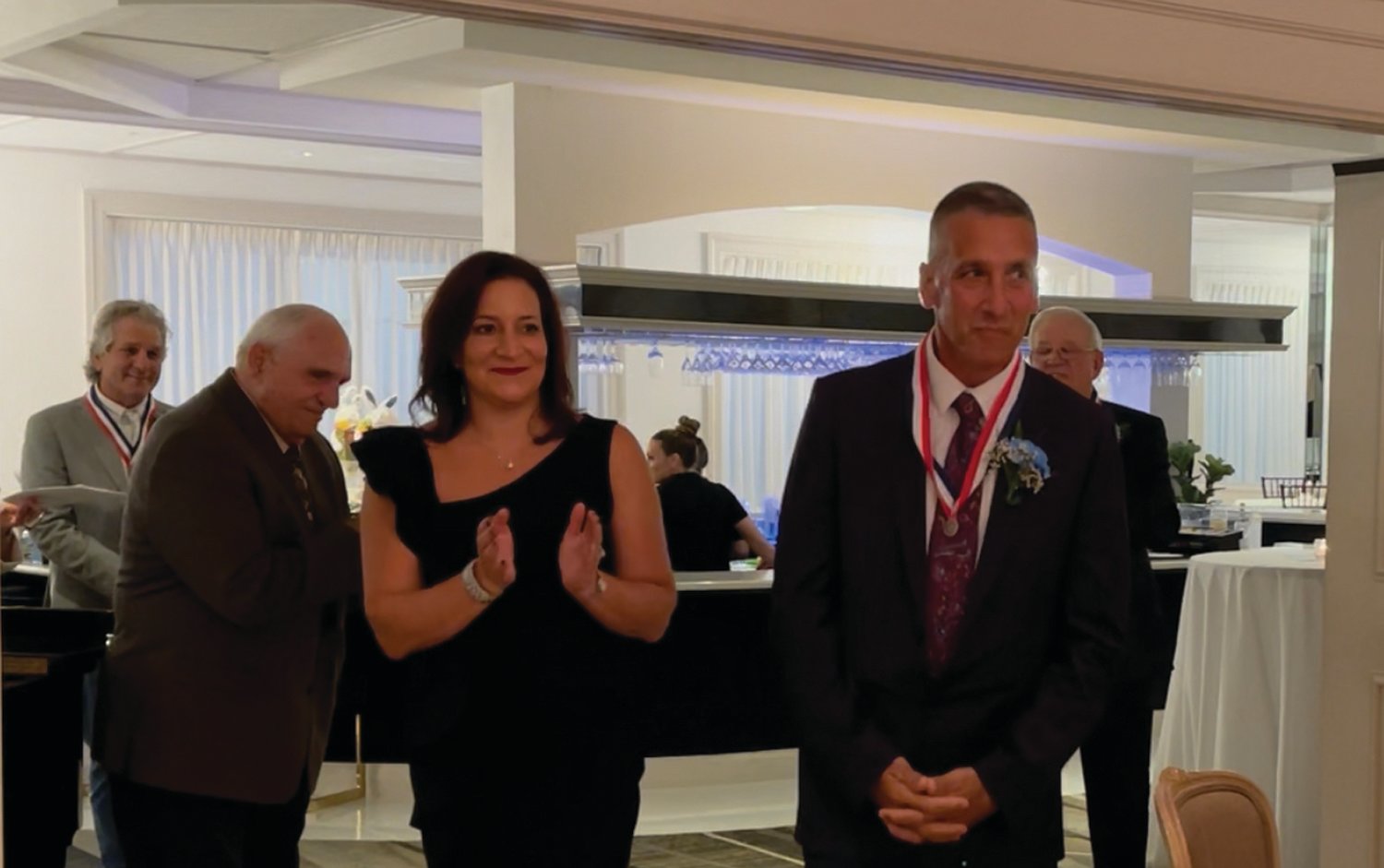 REASON TO SMILE: John Macera is escorted into last week’s Hall of Fame induction dinner by Superintendent Jeannine Nota-Masse. Looking on, from left, are Anthony Tomaselli, Ken Mancuso and William Stamp.
